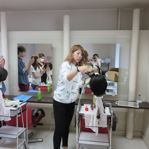 先輩がブローの方法についてお手本を見せている写真